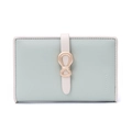 Close-up of light green Saffiano leather wallet with gold bow buckle and contrast piping - Green
