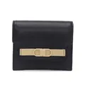 Detalle de cartera negra corta con correa de cuero beige y hebilla de metal dorado - Negro