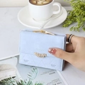 Detail of light blue tri-fold wallet with gold leaf charm on a stylish magazine background - Sky Blue