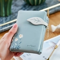 Portefeuille femme bleu clair à trois volets avec motif marguerites et boucle feuille - Bleu clair