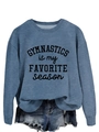 Close-up of fabric texture and 'GYMNASTICS is my FAVORITE season' print on blue sweatshirt - Blue Sweatshirt (Black Font)