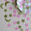 Close-up of gold glitter stars and moon confetti with pink paper stars for party decor - Gold Moon Pink Star Style