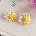 Detailed close-up of handmade raffia daisy earrings with white petals and yellow centers - Stud Style (25781B)