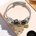 Detailed view of beaded bracelet featuring a pearl butterfly charm and gold heart pendant - Silver Black