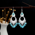 Artistic close-up of Bohemian turquoise tassel earrings hanging on a dry branch - Blue Silver (E2363-2)