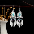 Detail of bohemian drop earrings with turquoise stones and silver feather tassels on wood - Multicolor(E4145)