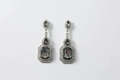 Close-up of vintage silver drop earrings featuring dark grey gemstones and pavé accents - Gray
