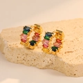Detail of gold huggie earrings with rainbow rectangular zircon stones on textured stone - Rainbow Pave Hoop Style (H-10879)