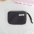 Close-up of polka dot canvas coin purse with zipper closure and May Rabbit label - Dark Grey Polka Dot