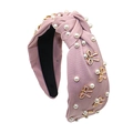 Detalle de diadema rosa anudada con perlas blancas y adornos de mariposas esmaltadas - Rosa