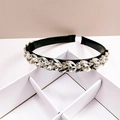 Dettaglio di cristalli scintillanti e strass su un cerchietto largo nero elegante - Bianco