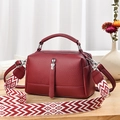 Burgundy faux leather crossbody bag with patterned strap on wooden tabletop surface - L24xH14xW10cm / Burgundy