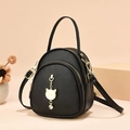 Mini black lychee leather backpack with a gold cat pendant and multi-way shoulder straps - Solid Black