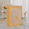 Bright yellow paper gift bag with transparent PVC window and gray woven handles - Yellow