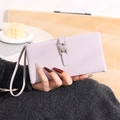 Close-up of lavender PU leather wallet with heart-shaped metal buckle and wrist strap - Purple