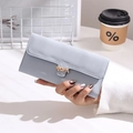 Elegante hellblaue lange PU-Ledergeldbörse mit goldener Blattschnalle in der Hand - Himmelblau