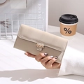 Close-up of apricot long wallet with golden leaf clasp held in a lifestyle setting - Beige Apricot