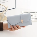 Macro detail of the light blue cross-grain faux leather wallet and flower buckle - Blue