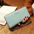 Mint green long zipper wallet for women with wrist strap shown in a lifestyle setting - Light Blue