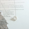 Collana con ciondolo argento irregolare esposta sopra un libro d'epoca - Argento