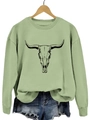 Détail d'un sweat-shirt vert clair avec imprimé crâne de taureau sur cintre en bois - Vert olive