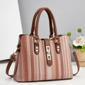 Close-up of striped woven tote bag with brown faux leather handles and gold metal buckle - 30 x 12 x 23cm / Pink
