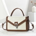 Detail of a minimalist crossbody bag with cream and brown leather patchwork and silver buckle - Brown & White
