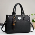 Dettaglio borsa nera con trama a grana, chiusura argentata e ciondoli decorativi fini - 33x13x23cm / Nero