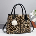 Bolso de leopardo moderno con colgante de peluche y correas de charol negro - Caqui