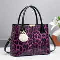 Detalle de bolso de leopardo morado con acabado brillante y colgante de perla y pelo - Morado