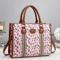 Détail du sac à main rose avec imprimés cerises, brides en cuir brun et rivets dorés - Rose