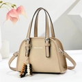 Close-up of beige canvas shoulder bag with fashion text and ethnic beaded charm - Khaki