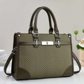 Detailed view of olive green tote bag with chevron texture and premium leather trim - Green