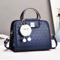 Dunkelblaue Handtasche mit Krokodilprägung, goldenen Metallgriffen und Plüsch-Anhänger - Blau