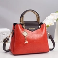 Détail du sac à main rouge en cuir de crocodile avec garniture dorée et breloque perle - Rouge