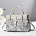 Elegant grey handbag with cloud embroidery and gold lock on minimalist marble background - Gray