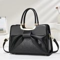 Detalle de bolso bandolera negro con diseño de lazo de cuero y texturas tejidas - Negro