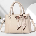 Details der beigen Handtasche aus genarbtem Leder mit Silberbeschlägen und Seidenschleife - 30x13x21cm / Khaki