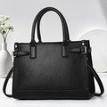 Dettaglio della borsa tote in pelle nera martellata con fibbie metalliche e doppi manici - 33x13x23cm / Nero