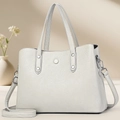 Detail of grey lychee leather texture with silver hardware and decorative button - Gray