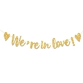 Detail van een gouden glitterbanner 'We're in love!' met harten voor bruiloftdecor - Gouden Letterstijl