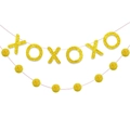 Detail of glittery yellow XOXO letters and soft pom-poms on a decorative banner - Gold XOXO Banner With Pom Pom String