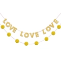 Dettaglio delle lettere LOVE glitterate e pompon gialli su una ghirlanda festiva - Banner LOVE Oro Con Corda Di Pompon