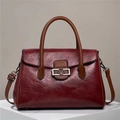 Dettaglio della borsa tote in pelle bordeaux con superficie testurizzata e fibbia a V - Borgogna