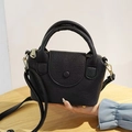 Détail du mini sac noir à motif litchi avec boucle ronde et garniture dorée élégante - Noir
