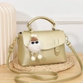 Golden textured leather crossbody bag with top handle and cute plush doll pendant - Gold