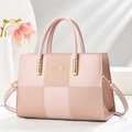 Detail view of pink patchwork handbag with woven texture and gold metal hardware - Pink
