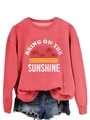 Close-up of coral pink sweatshirt featuring Bring On The Sunshine graphic print - Red (White Letters)