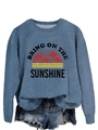 Close-up of Bring On The Sunshine graphic print on blue crewneck sweatshirt fabric - Blue (Black Print)