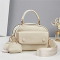 Schicke beige Umhängetasche aus Leder mit Jacquard-Gurt und Mini-Beutel auf weißem Grund - Weiß